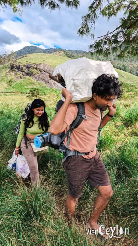 Hikers carrying camping gear to a campsite to set up their tent