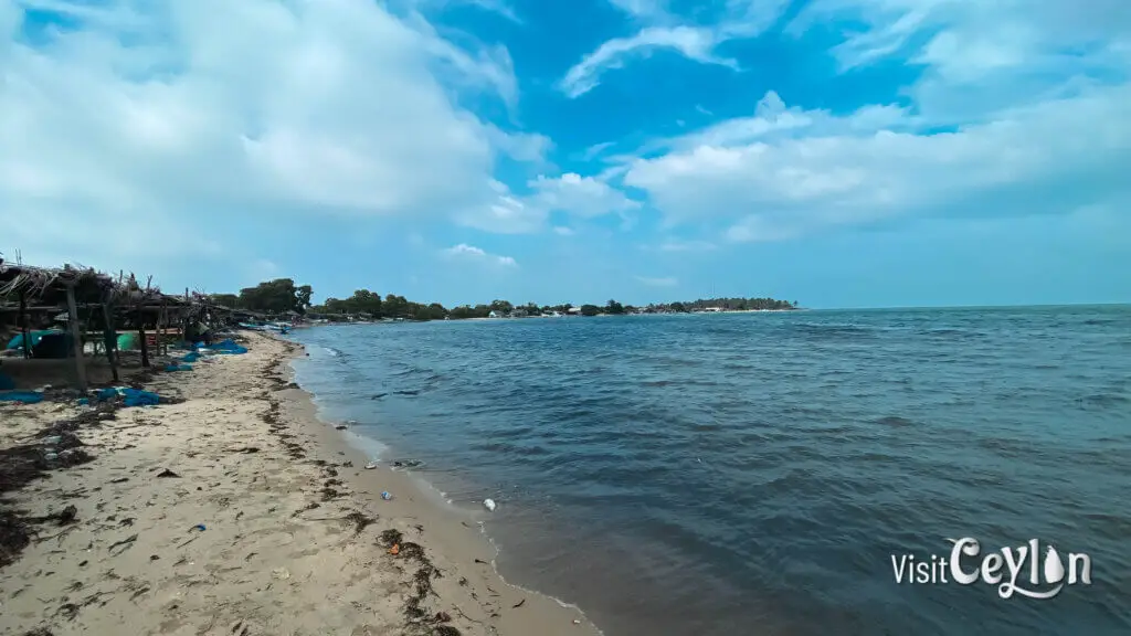 etty area of Baththalangunduwa Island with boats and calm waters.