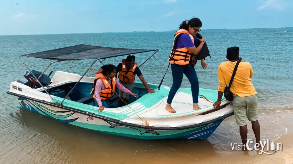 A boat arriving at an island beach with clear water and sandy shoreline.