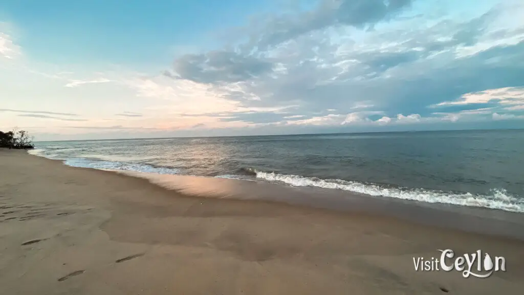 Sunset view at Baththalangunduwa Beach with golden sky and calm ocean waves.
