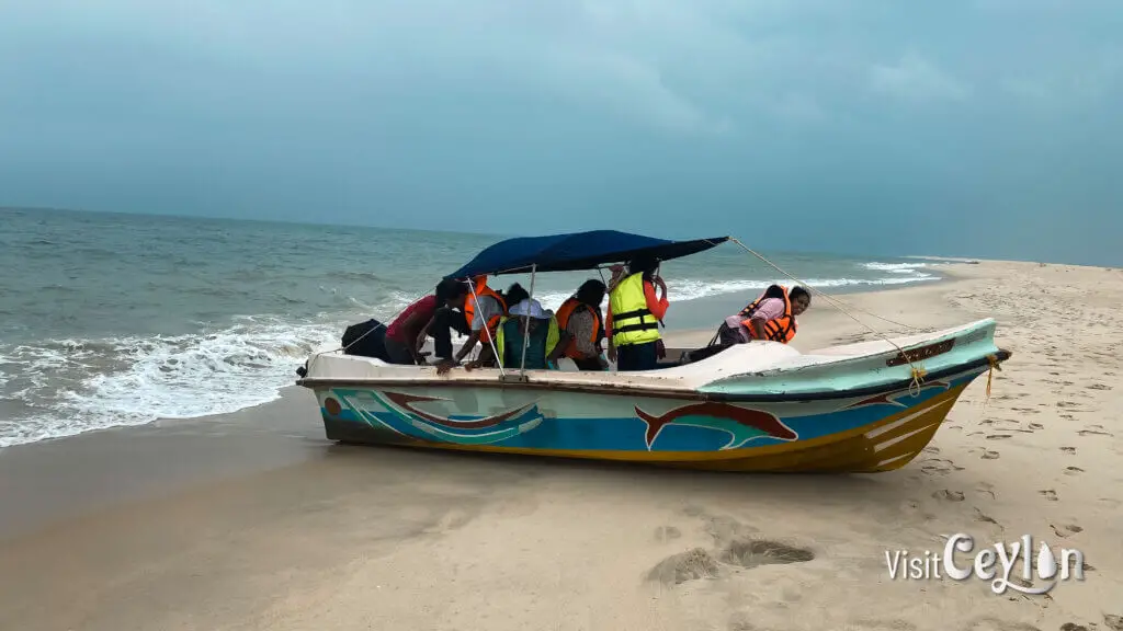 A boat arriving at a campsite near the beach with calm water and natural surroundings.