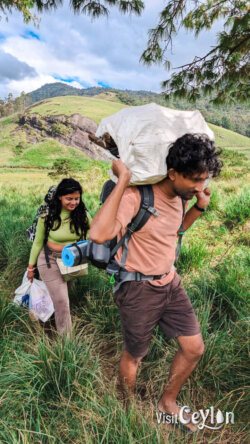 A photo of my self moving to arrange our campsite taken by Gihan Karunarathne on 2025.08.29 at 2.30pm Hikers carrying camping gear to a campsite to set up their tent